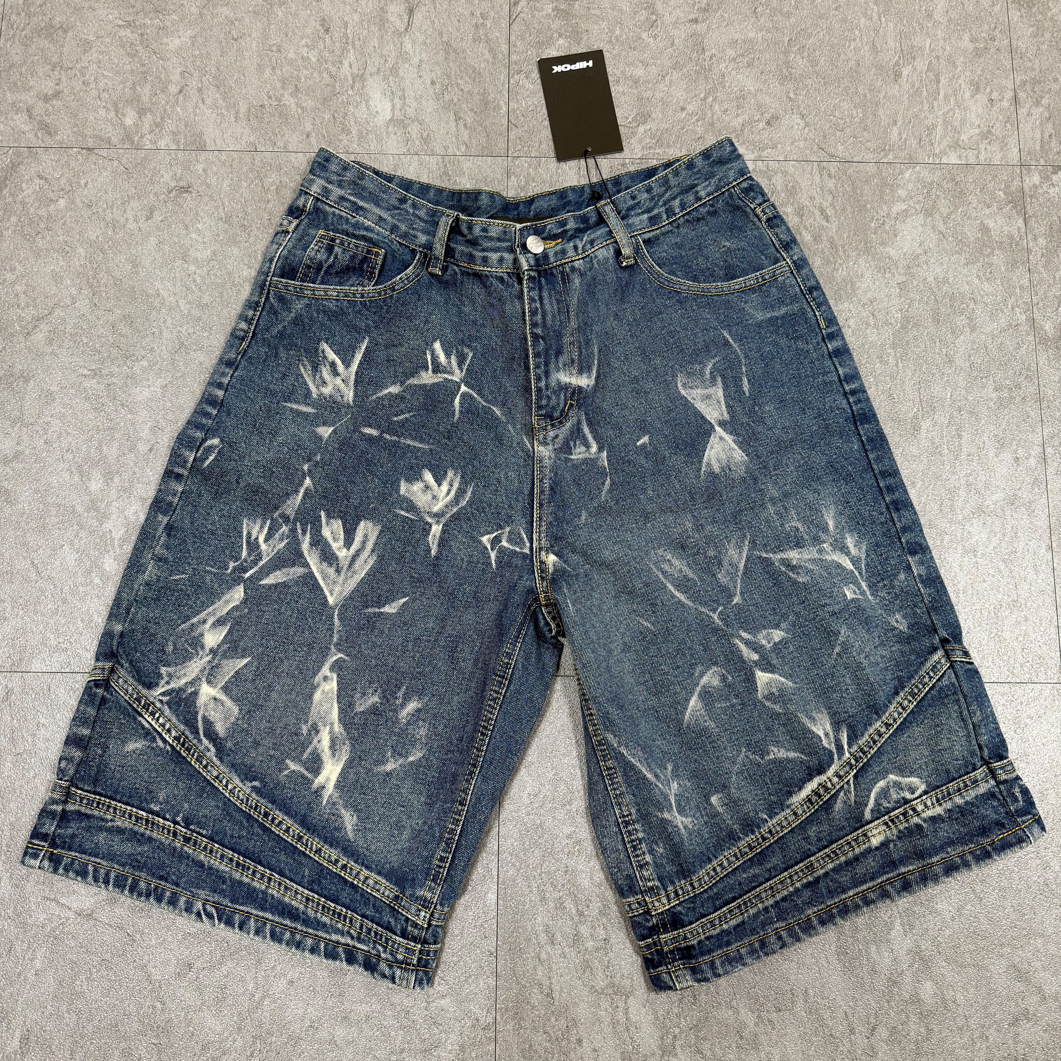 Washed blue denim shorts fully laid out on floor